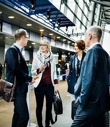 Accident & Health Business Travel Accident Meeting fellow business associates at airport terminal in the midst of travel