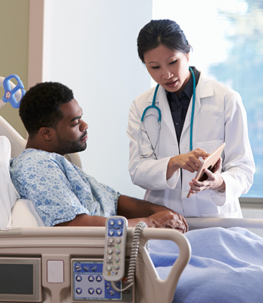 Voluntary Health Benefits Man with stable but critical condition discussing health status with doctor